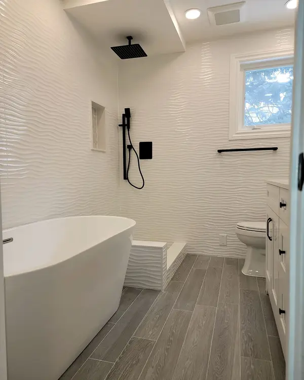 Freestanding tub with matte black fixtures in a renovated bathroom