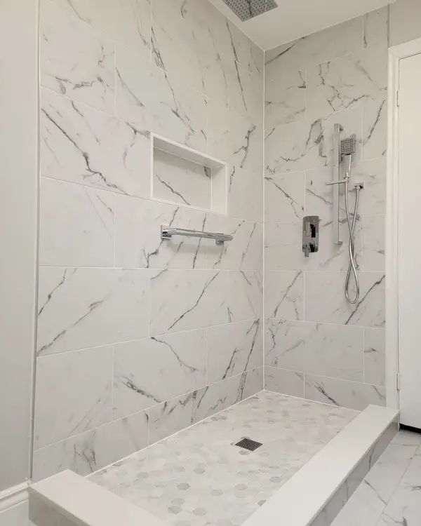 Marble-look shower walls with a long recessed niche