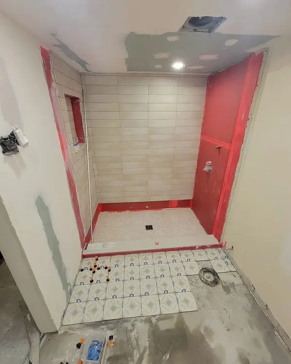 Red waterproofing membrane on a shower before tile, Toronto