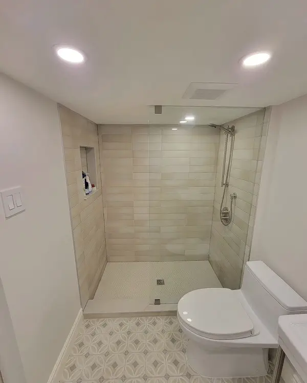 The finished basement bathroom with a glass shower and patterned floor