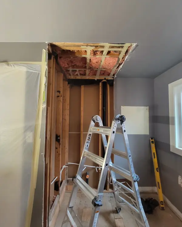 The same bathroom stripped back to the framing before the rebuild