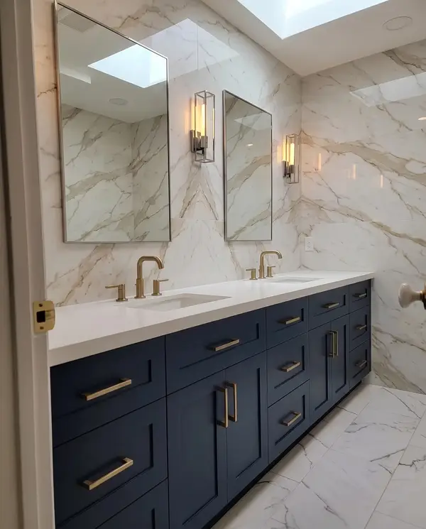 Navy double vanity under a skylight with twin mirrors