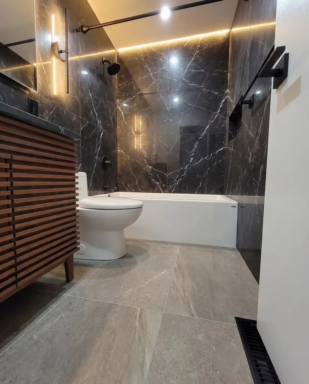 Walnut slat vanity against black marble-look slabs